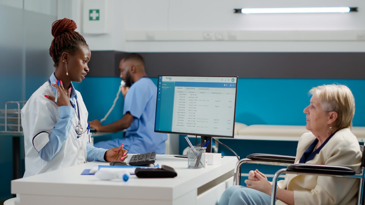 african american doctor doing checkup visit with female wheelchair user talking about physical disability healthcare diagnosis consulting woman with impairment medical appointment